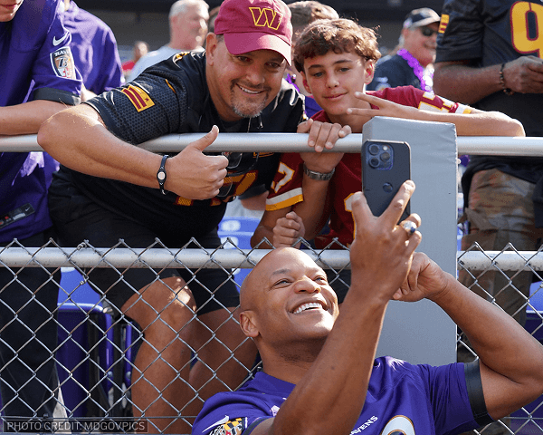 Wes taking a selfie with two Commanders fans